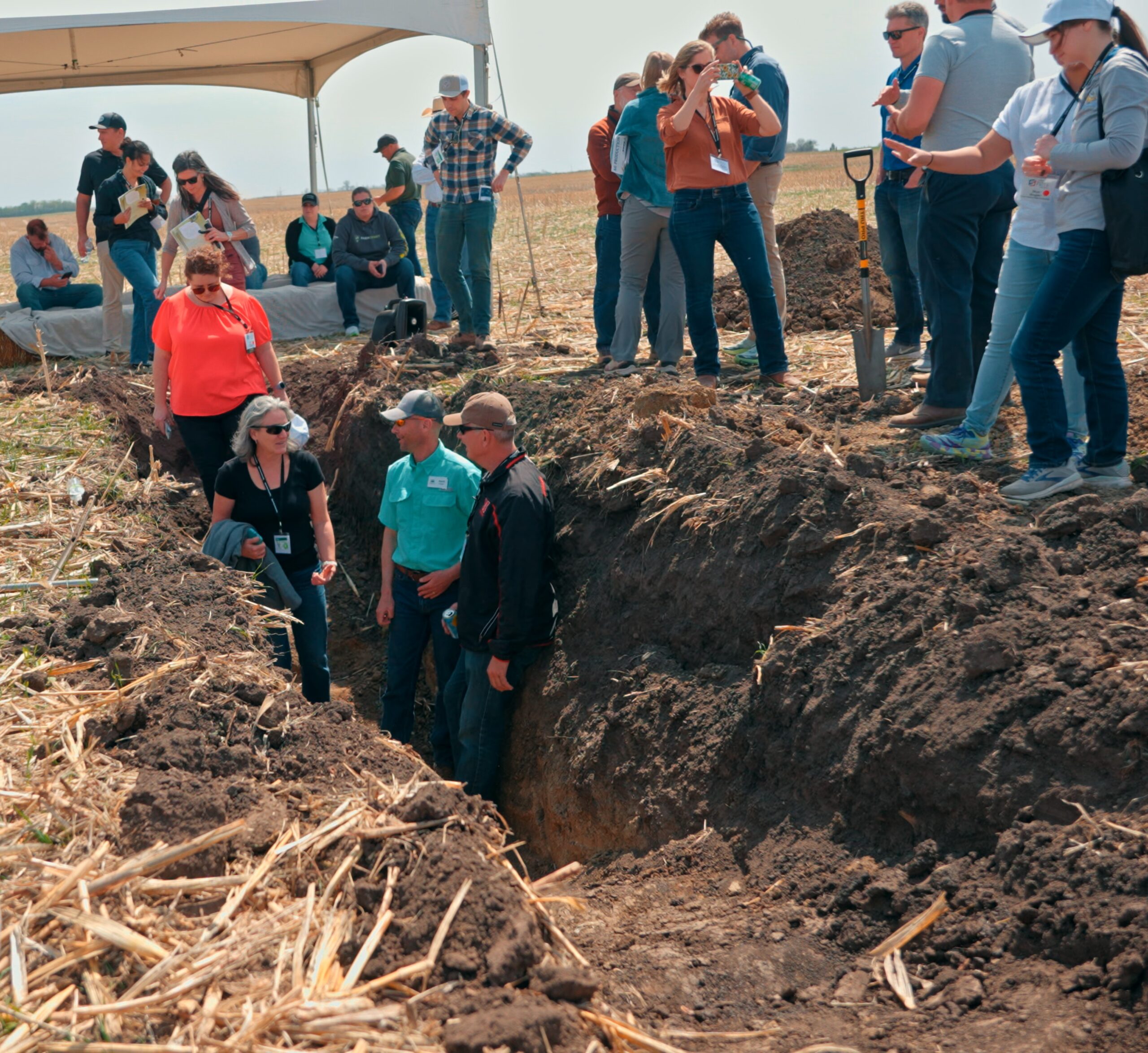 2025 Tour Attendees in Soil Pit Tour participants and speakers in around around soil pit in field.